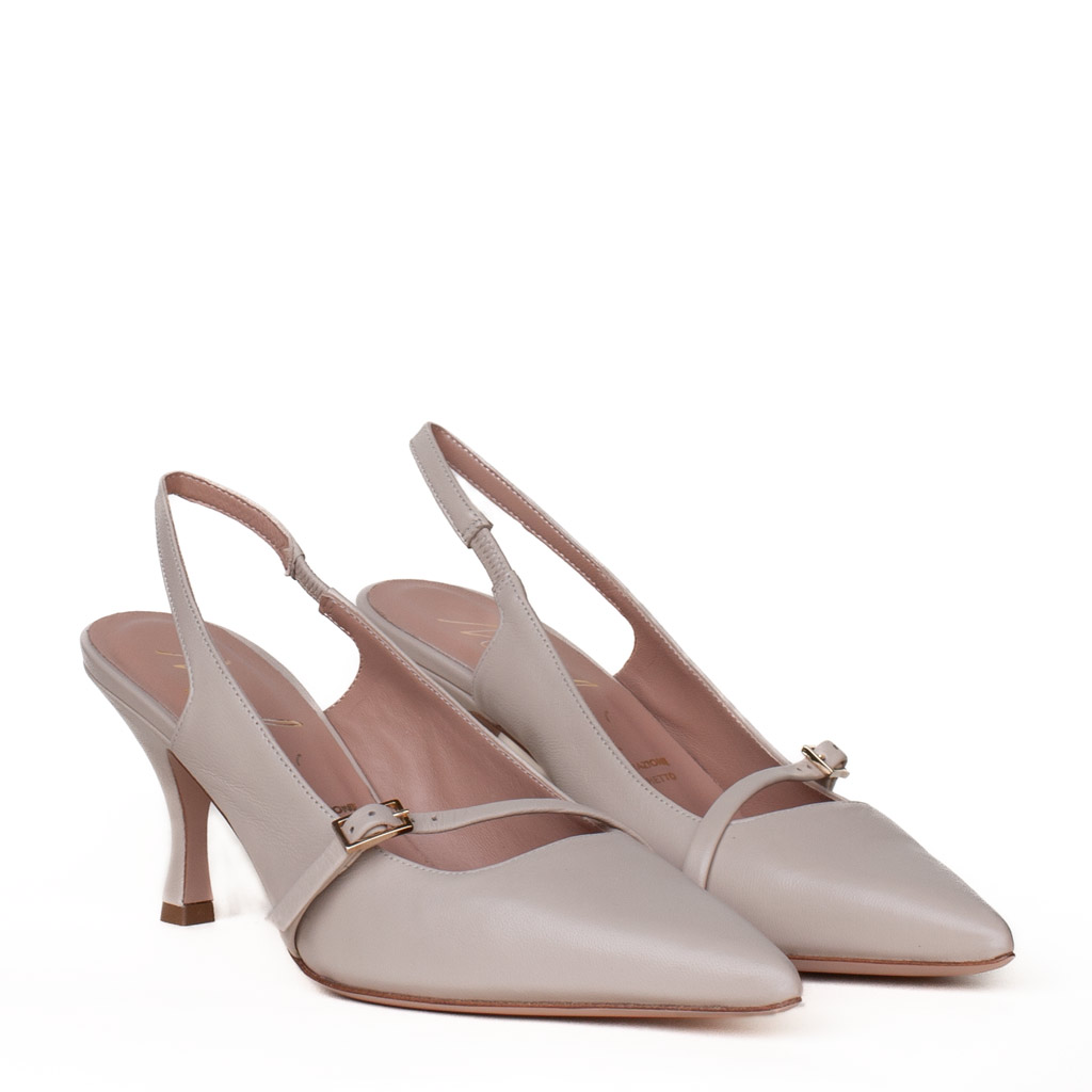 Elegant Chanel-style pumps in cream, with a medium heel and a gold buckle.