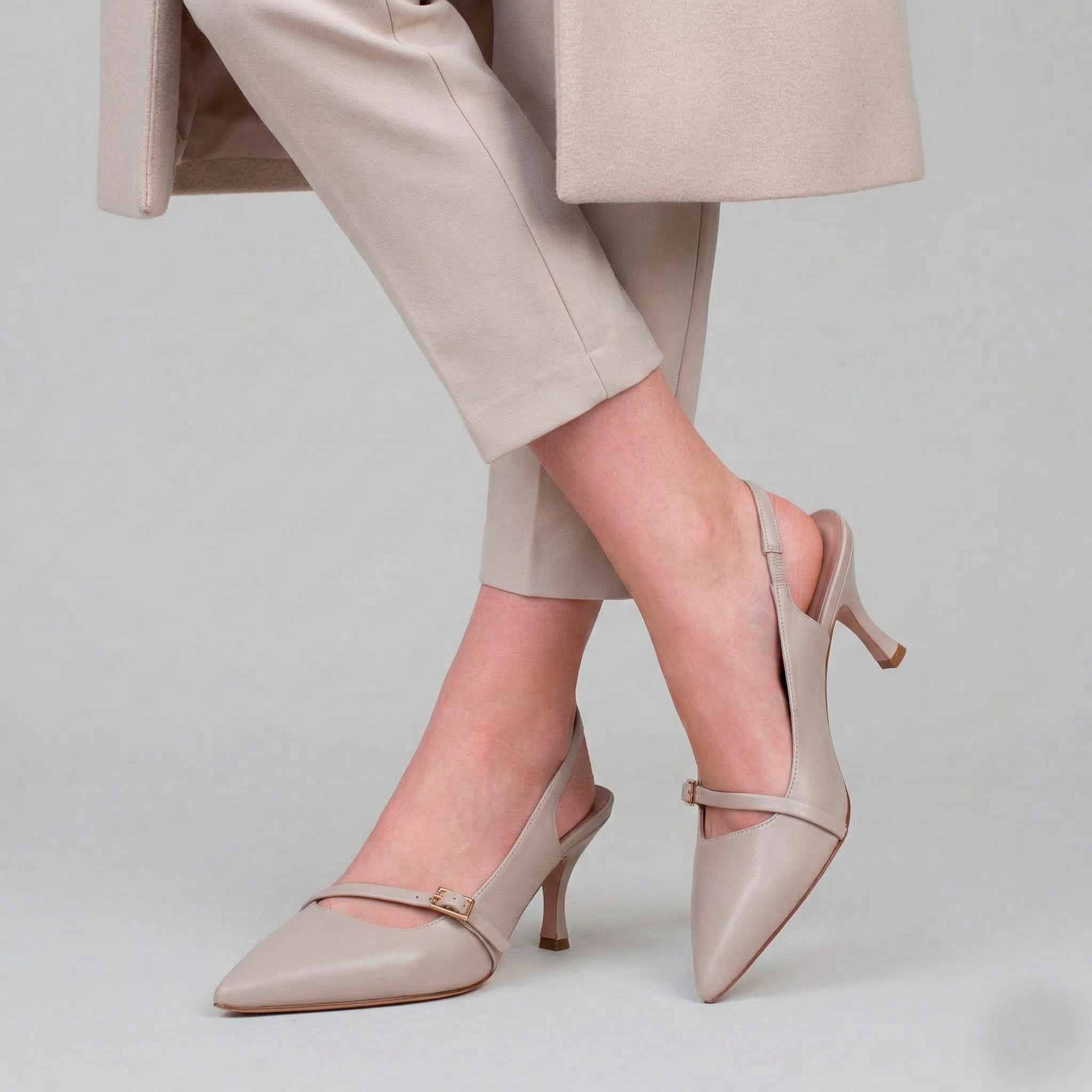 Scarpe eleganti modello Chanel a sacchetto panna con tacco medio e fibbia dorata.